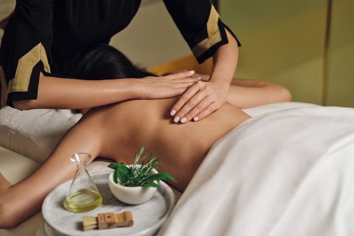 Spa therapist perfofrming a massage on a woman's back