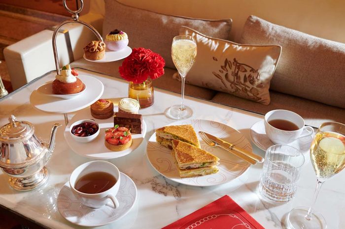 La Galerie Tea Time with a selection of Angelo Musa’s signature pastries, a traditional club sandwich, tea and champaign, set on a marble table, at Hotel Plaza Athénée, Paris